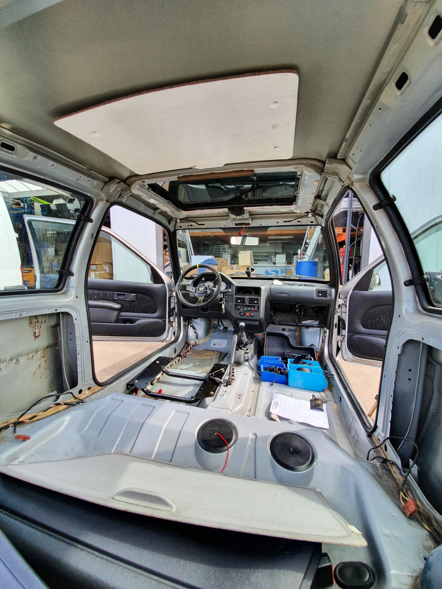 Bare interior of the car seen from the rear hatch, seats and panels removed