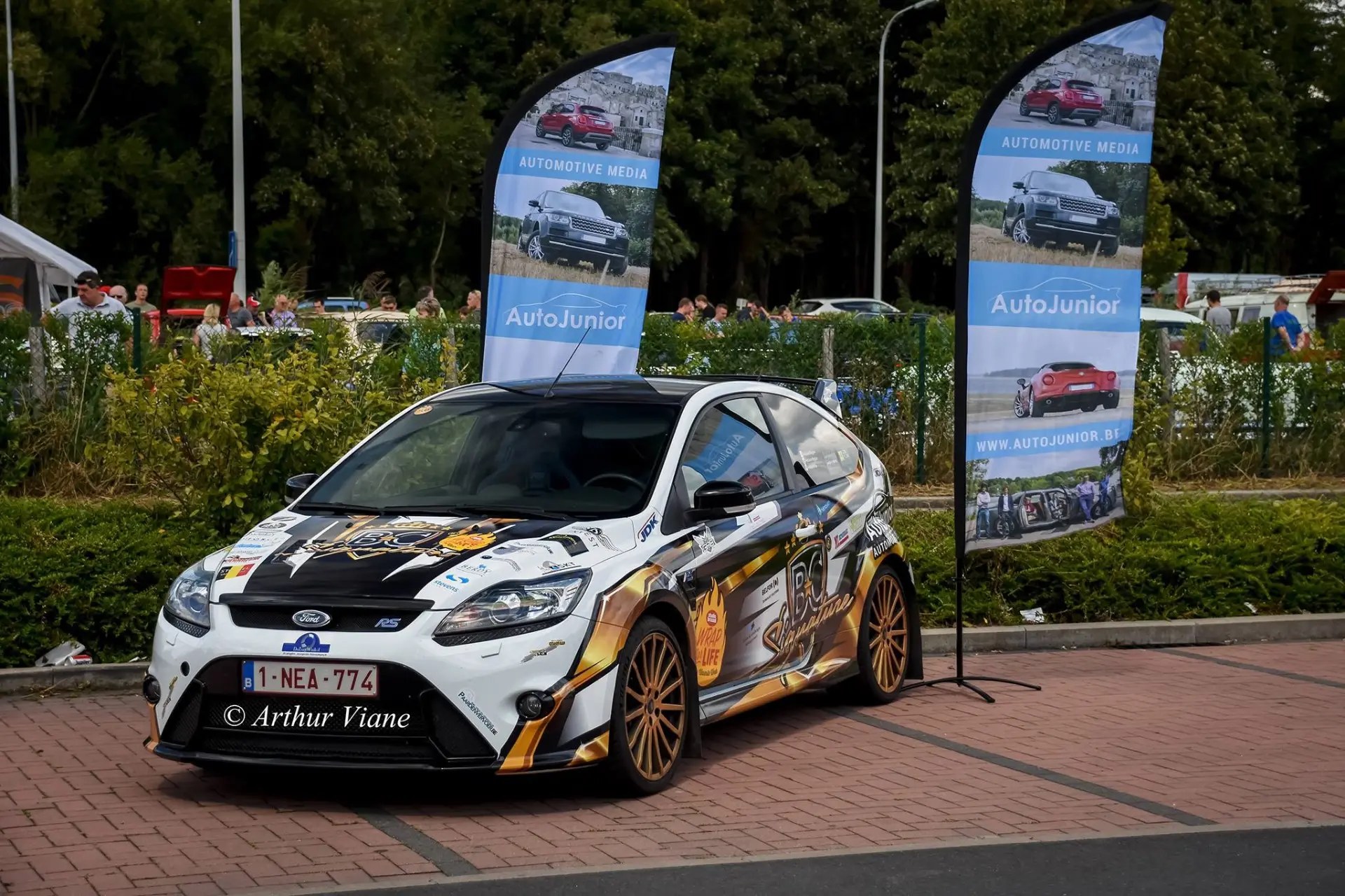 A rally-liveried hatchback displayed between AutoJunior banners